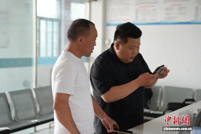 村干部冯大吉正在帮村民缴纳养老保险。张俊 摄