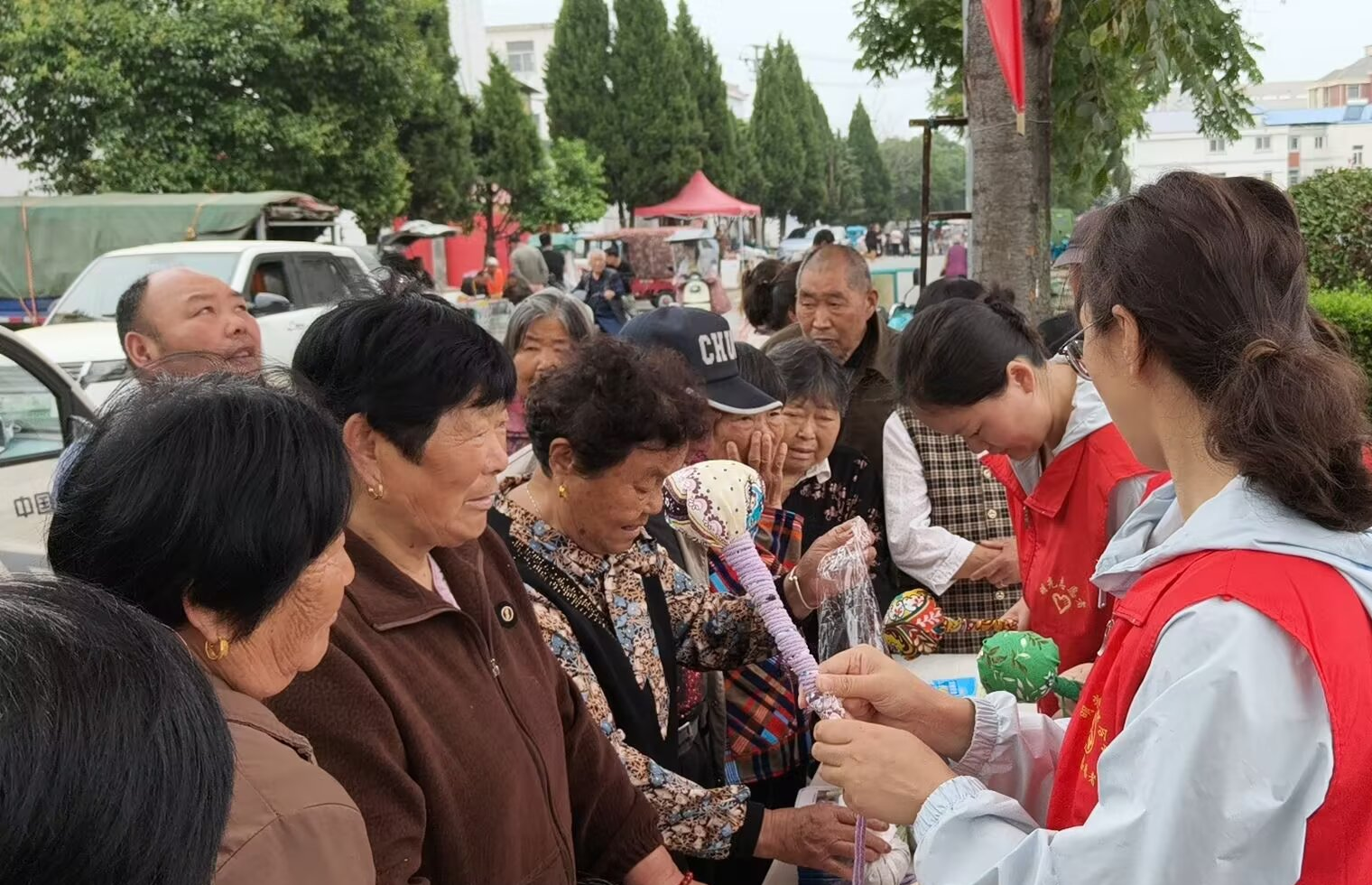 宣传人员编织艾草锤分发给群众。