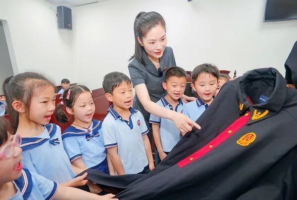 淮北市相山区法院干警为幼儿园小朋友介绍法袍。 单鹏里 摄