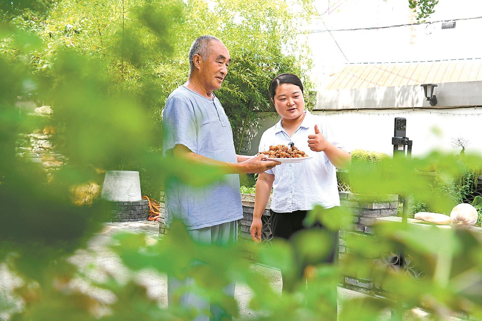 近日，淮南市八公山区山王镇闪冲村党支部书记、村委会主任刘棉（右），带领村民通过网络直播推介特色美食。通讯员 陈彬 摄